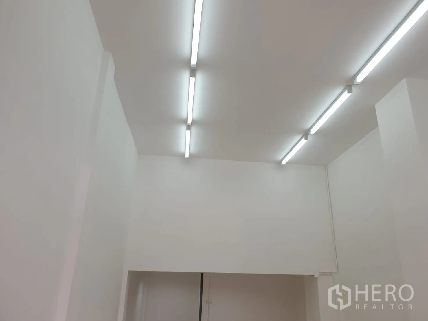 零售空间 出租在Chatuchak, Bangkok - 店内白色高顶上的线性灯特写。
