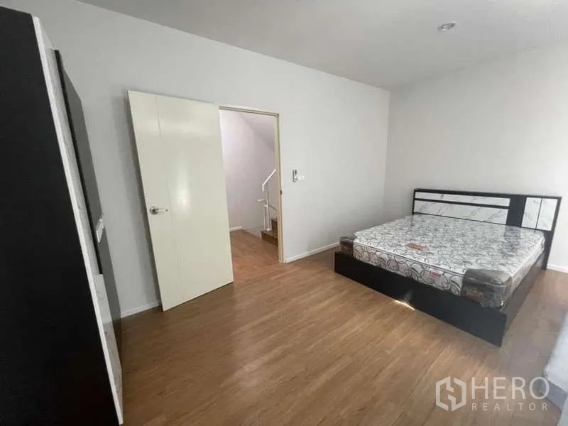 Townhouse for rent or sale in Phasi Charoen, Bangkok - Spacious bedroom with double bed, wardrobe and wood floors.