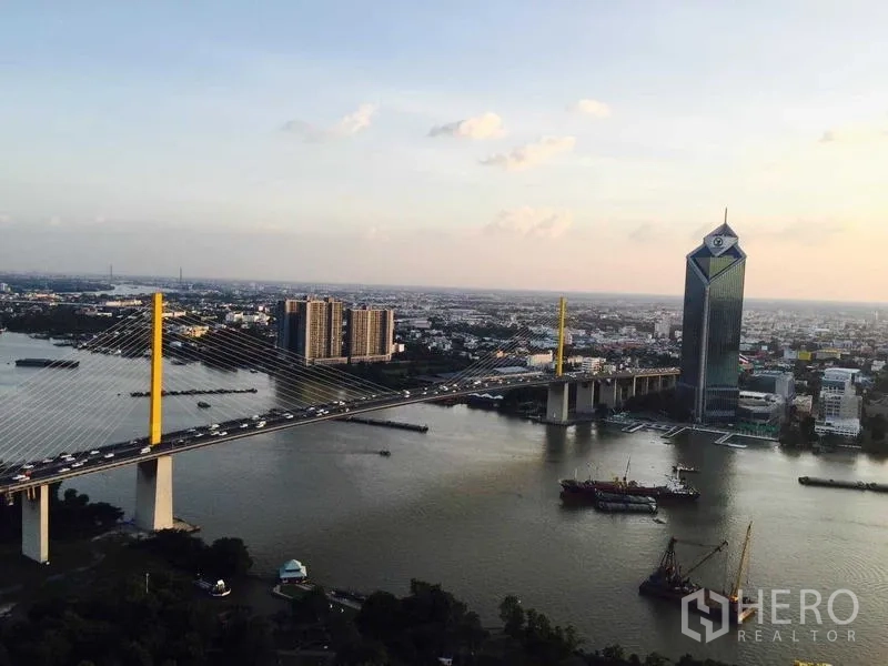 Condominium for sale - Daytime panorama of a cable-stayed bridge over the Chao Phraya River with skyline beyond.