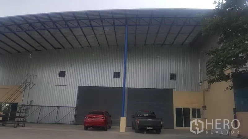 工厂 出租在Khlong Luang, Pathum Thani - 空銮区钢结构工厂外立面，高挑雨棚、卷闸门与前方停车区