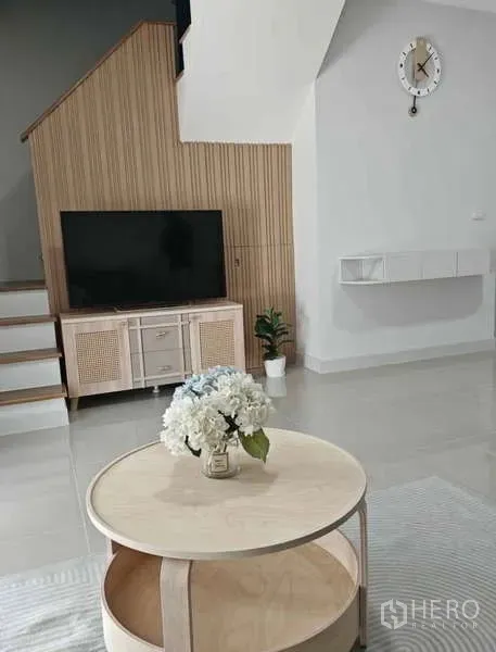 ทาวน์เฮาส์ ให้เช่าในBang Phli, Samut Prakan - มุมห้องนั่งเล่นทันสมัย ตู้ทีวีติดบันได พื้นกระเบื้อง และโต๊ะกลางไม้โทนอ่อน