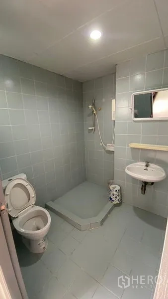 联排别墅 出租在Bang Na, Bangkok - 简洁瓷砖浴室，开放式淋浴、坐便与挂墙洗手盆。