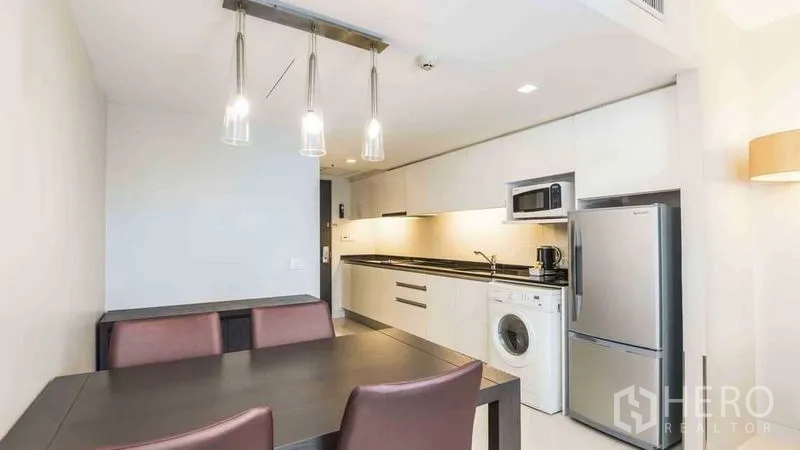 Apartment for rent in Watthana, Bangkok - Linear kitchen with fridge, microwave, washing machine and ample cabinets.