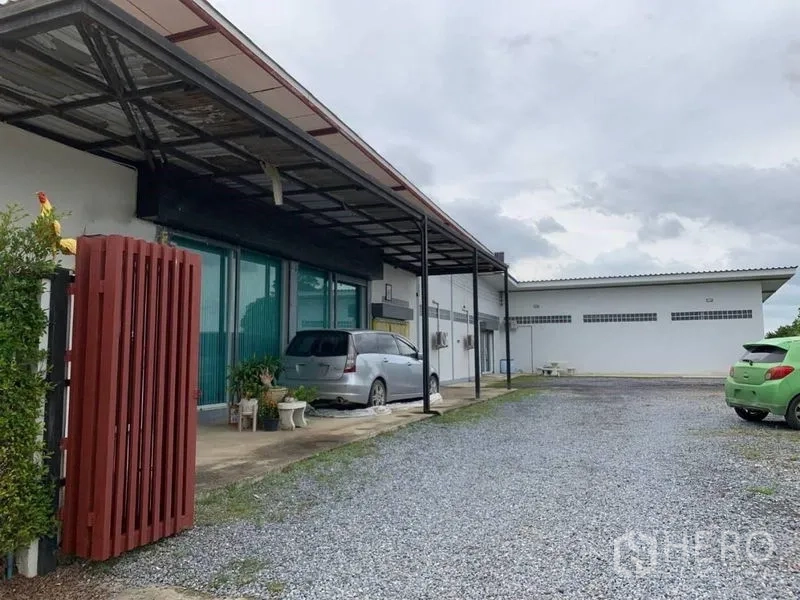 工厂 出售在Bang Pa-in, Phra Nakhon Si Ayutthaya - 单层工厂外观，带有遮雨装卸棚、玻璃办公区与碎石停车区。