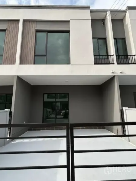 Townhouse for rent in Bang Phli, Samut Prakan - Modern two-storey townhouse facade with covered carport and sliding gate.