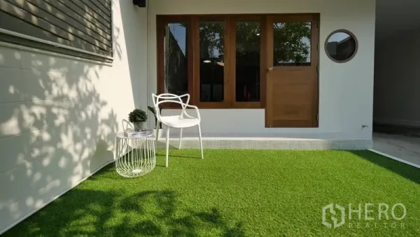 ทาวน์เฮาส์ ให้เช่าในKhlong Toei, Bangkok - เฉลียงกลางแจ้งปูหญ้า เก้าอี้เดี่ยว และหน้าต่างวงกบไม้บานใหญ่