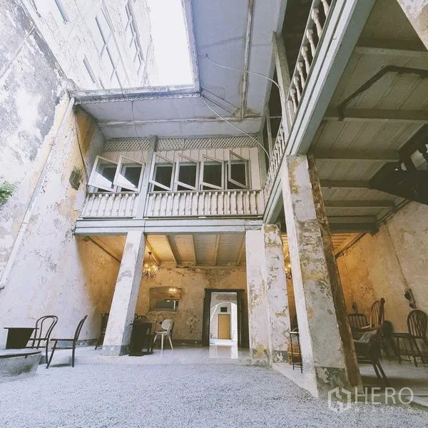 Shophouse for rent in Bang Rak, Bangkok - Open-air atrium with high roof void, gravel floor, and wraparound balconies.