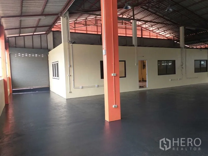 货栈 出租在Khlong Sam Wa, Bangkok - 室内区含卷帘门、橙色立柱与内置办公室。