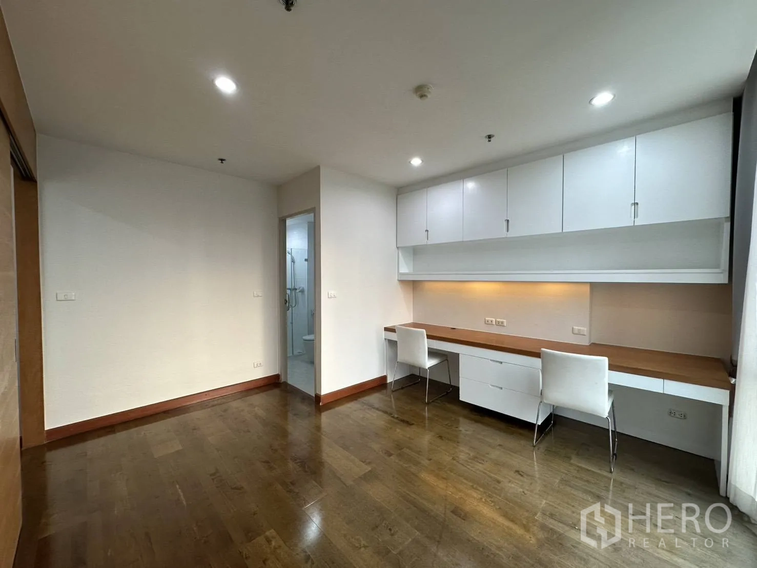 Condominium for rent in Watthana, Bangkok - Multipurpose room with extensive built-in worktop, overhead cabinets, and doorway to bathroom.