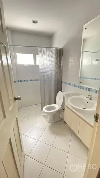 独立式住宅 出租 - 白色瓷砖浴室，带洗手台、镜子、座便器和带窗的淋浴区。