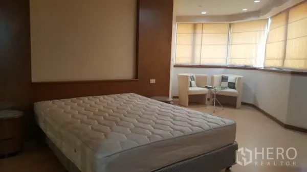 คอนโด ให้เช่าในKhlong Toei, Bangkok - ห้องนอนมาสเตอร์มีฐานเตียงขนาดคิง มุมนั่งเล่นริมหน้าต่างเบย์วินโดว์ และงานไม้โทนอุ่น