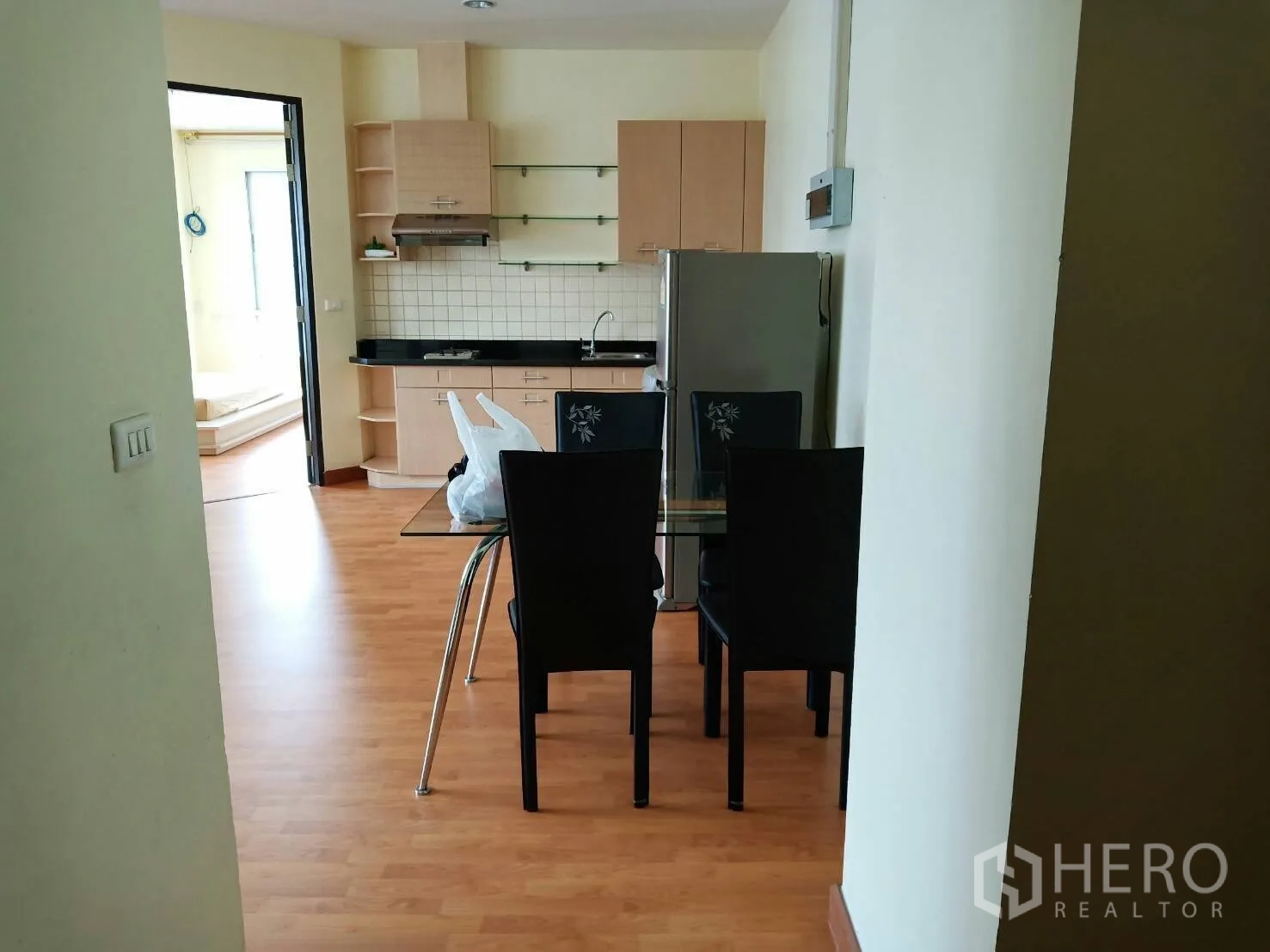 คอนโด ให้เช่าในKhlong Toei, Bangkok - มุมรับประทานอาหารโต๊ะกระจก 4 ที่นั่ง ข้างครัวและตู้เย็น มองเห็นทางเข้าห้องนอน