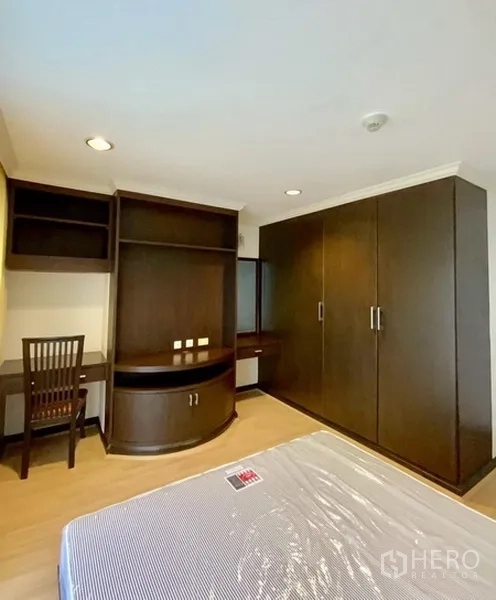 คอนโด ให้เช่าหรือขายในWatthana, Bangkok - อีกมุมของห้องนอนรองพร้อมตู้เสื้อผ้าบิวท์อิน โต๊ะทำงาน และพื้นไม้