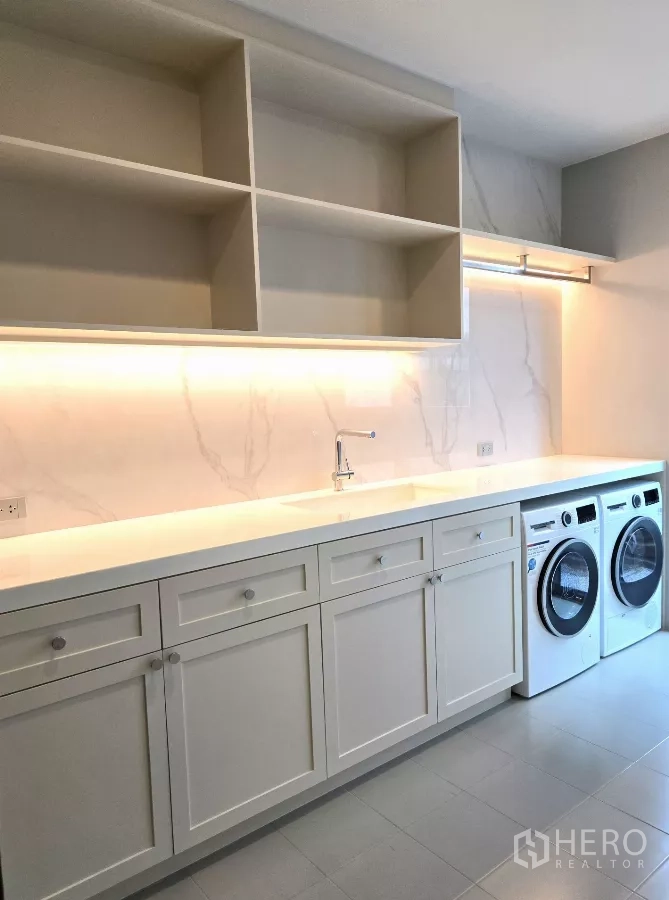 Detached House for rent in Bang Phli, Samut Prakan - Large laundry room with long countertop, sink, and side-by-side washer and dryer.