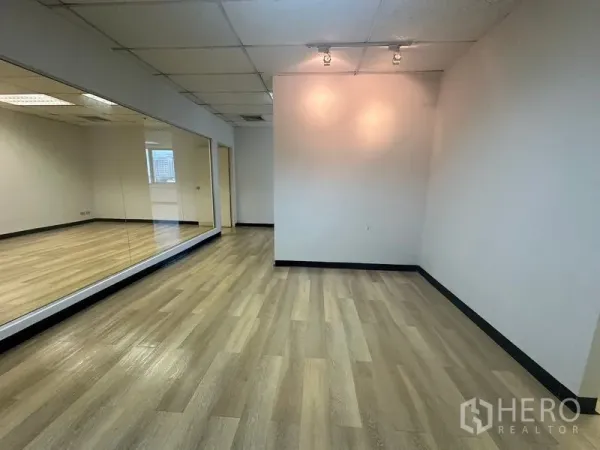 办公空间 出租在Phra Khanong, Bangkok - 独立办公区域，木地板、射灯墙面与整面镜墙设计。