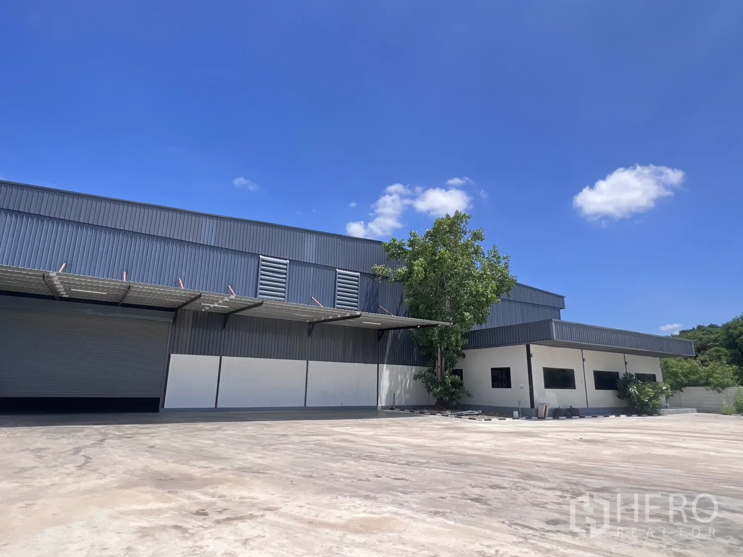 Warehouse for rent in Mueang Samut Sakhon, Samut Sakhon - Loading bay with roller shutter, canopy, and ventilation panels on the facade.
