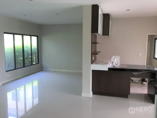 Detached House for rent or sale in Prawet, Bangkok - Open-plan living and dining area with large windows and a breakfast bar.