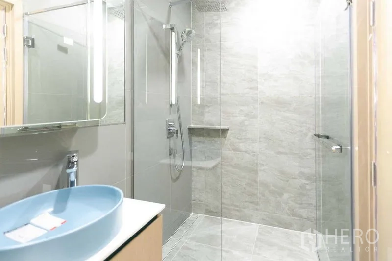 คอนโด ขายในWatthana, Bangkok - ห้องน้ำสไตล์โมเดิร์น พร้อมตู้กระจก ฝักบัวเรนชาวเวอร์ กั้นกระจก และกระเบื้องโทนเทา