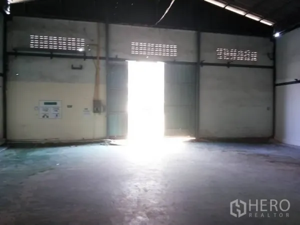 货栈 出租在Bang Sao Thong, Samut Prakan - 大型金属双开门，采光充足的仓库出入口区域。