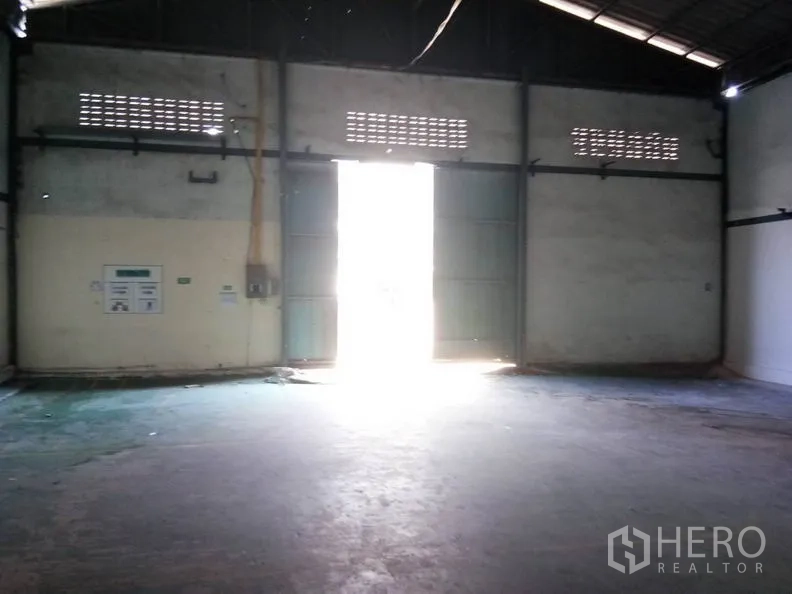 货栈 出租在Bang Sao Thong, Samut Prakan - 大型金属双开门，采光充足的仓库出入口区域。