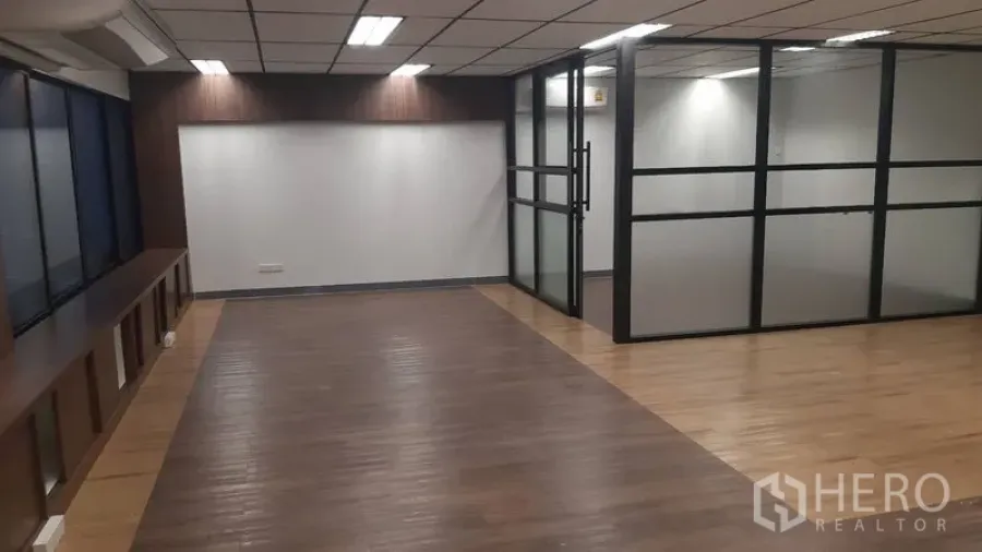 Office Space for rent in Chatuchak, Bangkok - Open-plan office with wood flooring, drop ceiling lights, and a glass-partition meeting room.