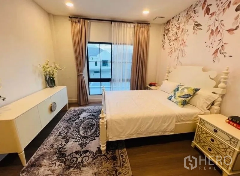 Detached House for rent or sale in Saphan Sung, Bangkok - Cozy bedroom with feature wallpaper, large window and decorative rug.