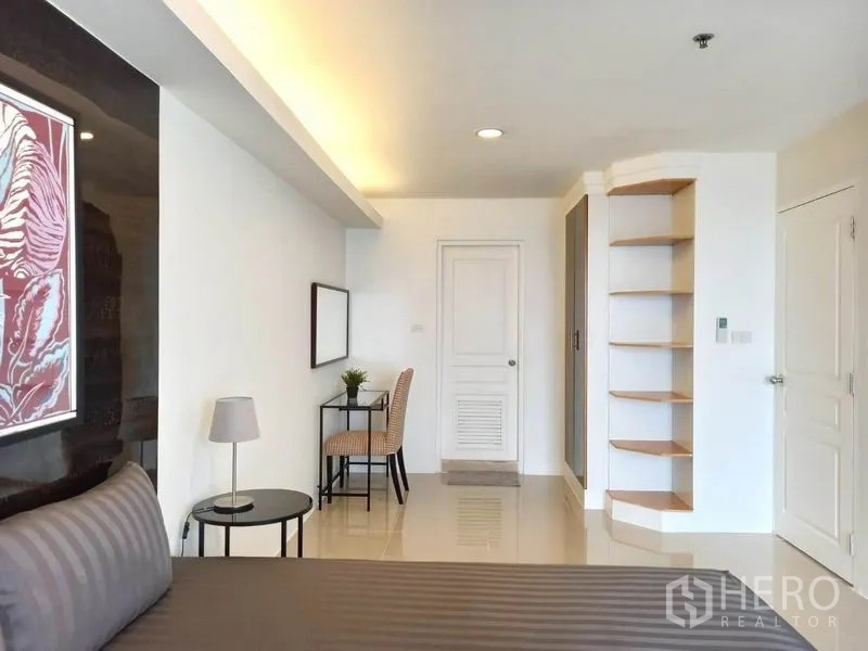 公寓 出租在Khlong Toei, Bangkok - 明亮的主卧，带书桌、转角置物架和亮面地砖。