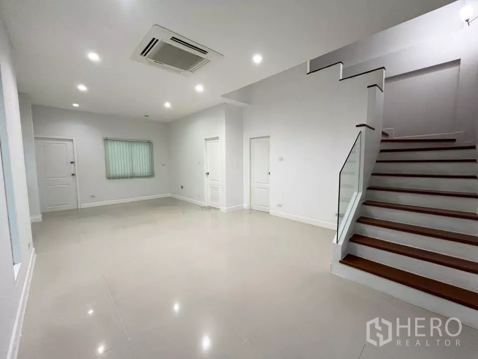 Home Office for rent in Bueng Kum, Bangkok - Spacious ground-floor hall with glossy tiles, staircase and ceiling cassette air-con.