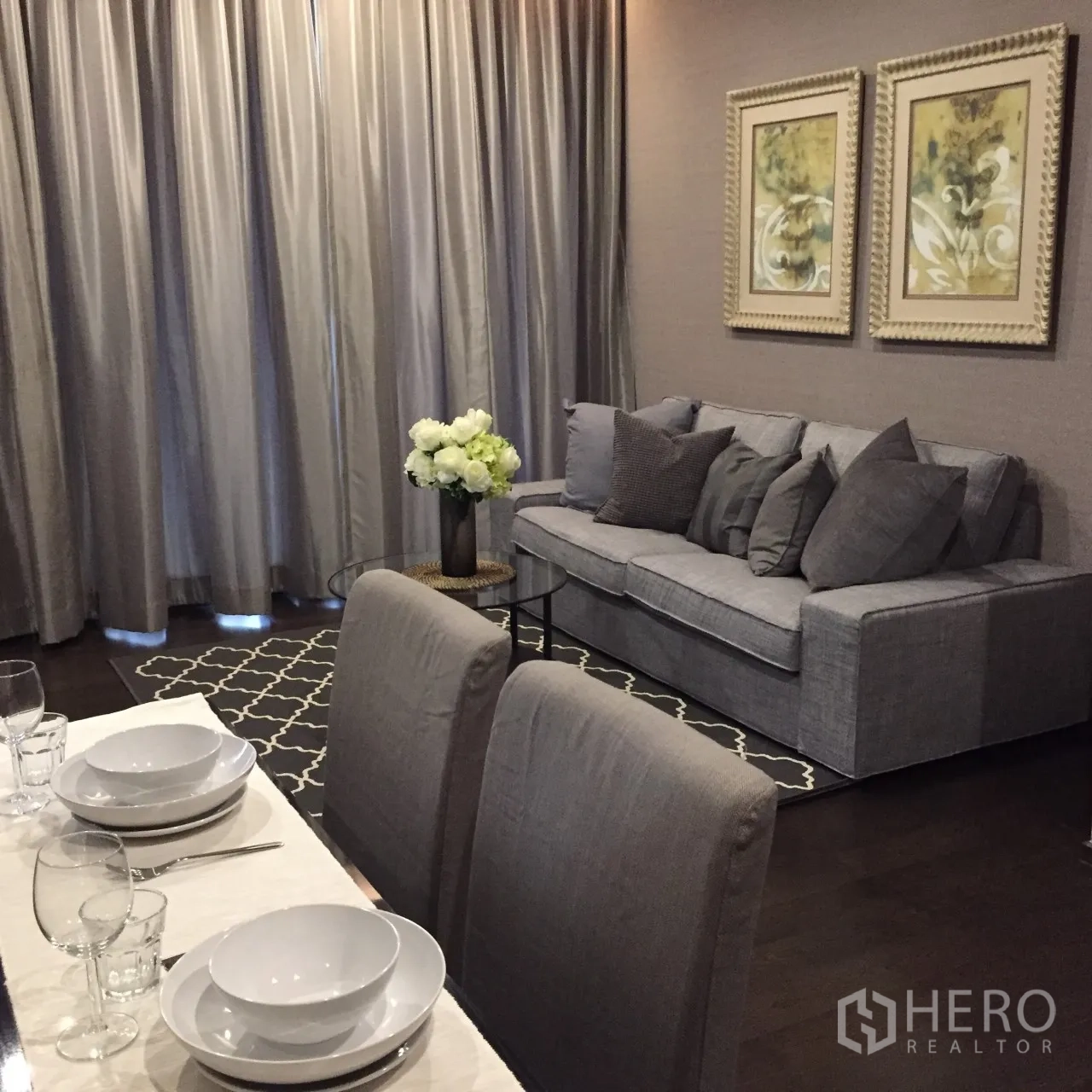 公寓 出租在Watthana, Bangkok - 餐区临长窗帘与落地窗，旁有舒适沙发和图案地毯，澎蓬公寓。