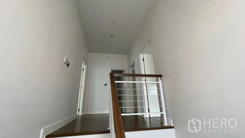 บ้าน ให้เช่าในBang Kapi, Bangkok - โถงชั้นบน พื้นไม้ ราวกันตกสีขาว และประตูห้องต่าง ๆ