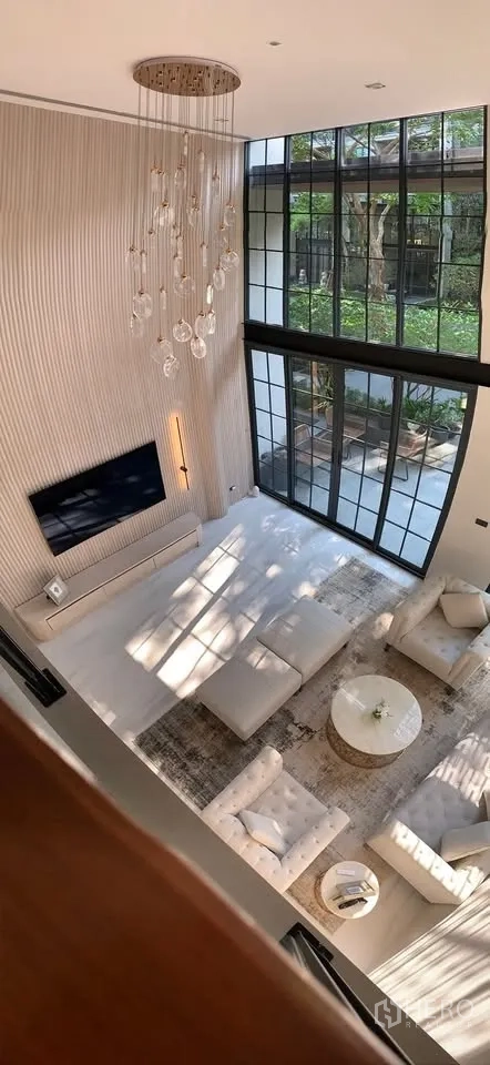 Townhouse for rent or sale in Watthana, Bangkok - View from the mezzanine over the bright living room and tall windows.