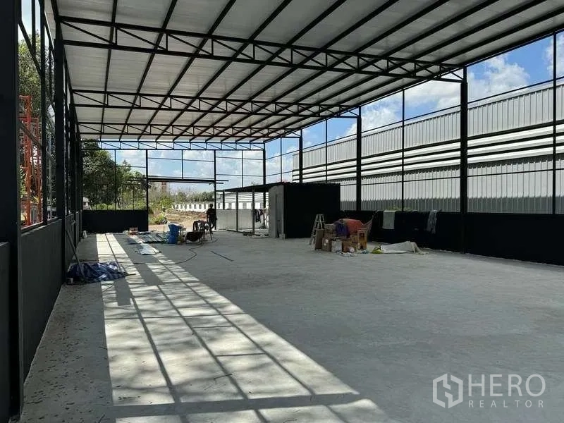 货栈 出租在Mueang Pathum Thani, Pathum Thani - 内部大开间，桁架屋顶与自然采光，地面为平整混凝土。