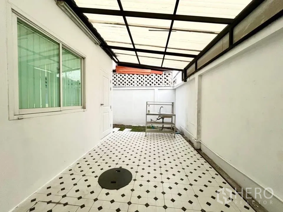 Home Office for rent in Bueng Kum, Bangkok - Roofed side patio with patterned tiles, utility sink and small grass strip