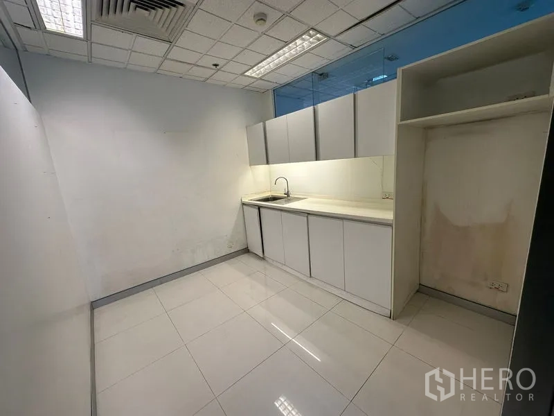 Office Space for rent - Pantry with white cabinetry, sink, tiled floor and overhead lighting.