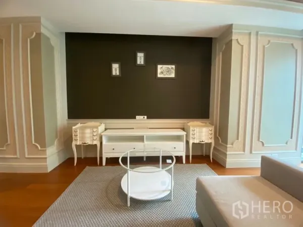 คอนโด ให้เช่าในKhlong Toei, Bangkok - ห้องนั่งเล่นคอนโดสไตล์คลาสสิก ผนังบัวกรอบ ทีวีคอนโซลสีขาว และโต๊ะกลางทรงกลม