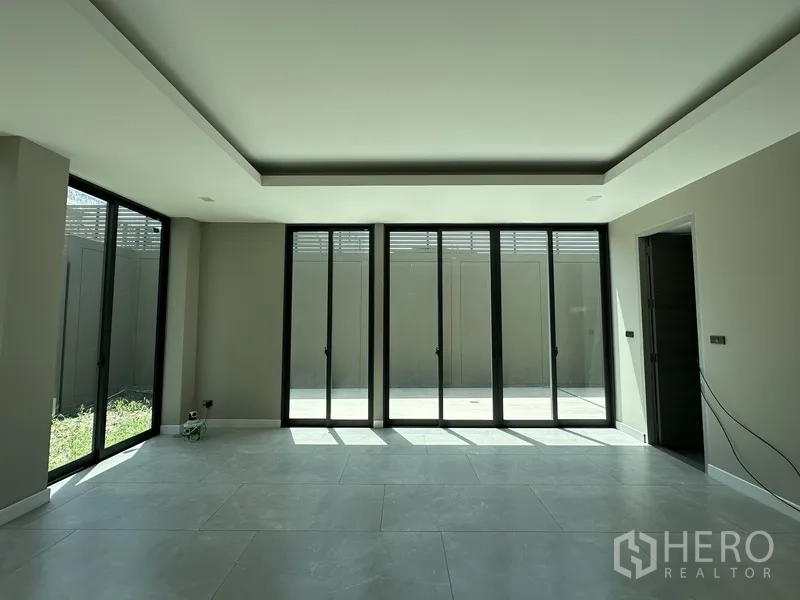 โฮมออฟฟิศ for rent or sale in Suan Luang, Bangkok - ห้องโล่งสว่างด้วยประตูกระจกบานเลื่อนเต็มผนังเปิดสู่ลานและสวน