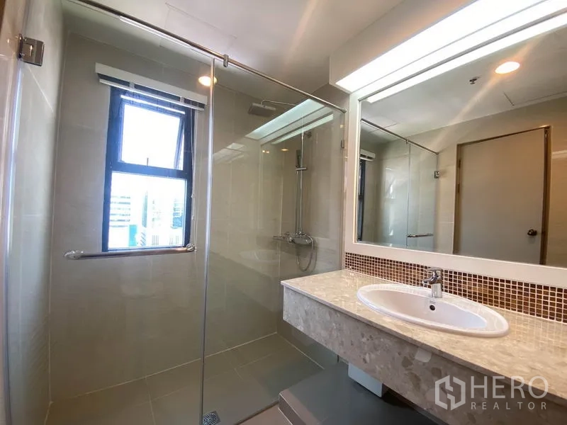 公寓 出租在Watthana, Bangkok - 浴室设玻璃淋浴间、采光窗与石材洗手台。