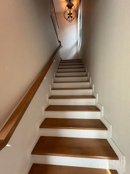 Detached House for rent in Prawet, Bangkok - Wooden staircase with handrail and modern pendant light.