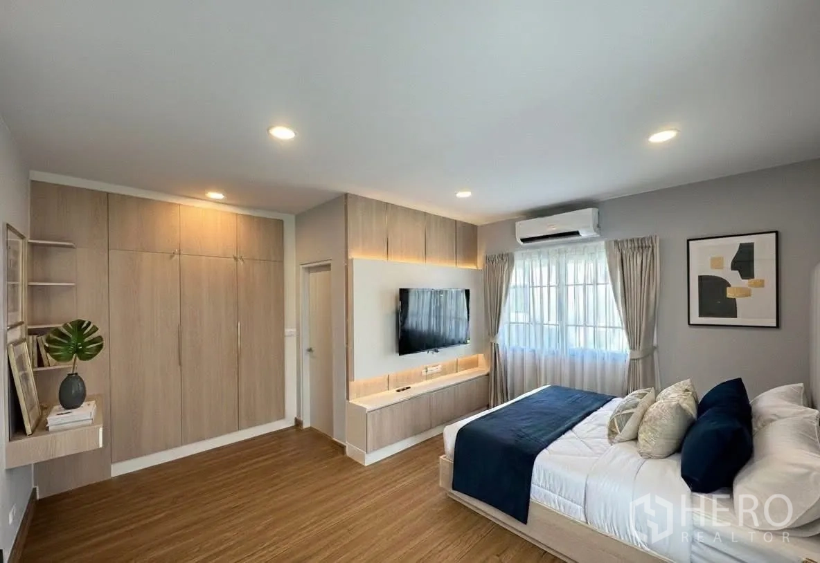 Detached House for rent in Bang Phli, Samut Prakan - Spacious master bedroom with TV wall, built‑in storage, air conditioning, and large bed.