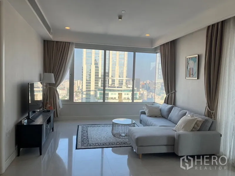 คอนโด ให้เช่าในPathum Wan, Bangkok - ห้องนั่งเล่นสว่าง มีหน้าต่างบานใหญ่ โซฟาเข้ามุม และวิวตัวเมือง