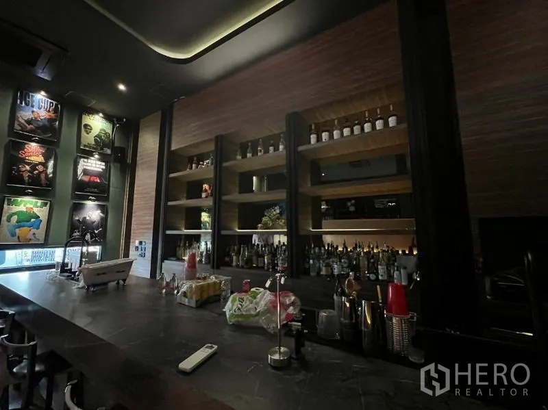 พื้นที่ขายปลีก ให้เช่าในWatthana, Bangkok - ผนังหลังบาร์ติดชั้นไม้บิวท์อิน วางขวดเครื่องดื่มและกรอบโปสเตอร์