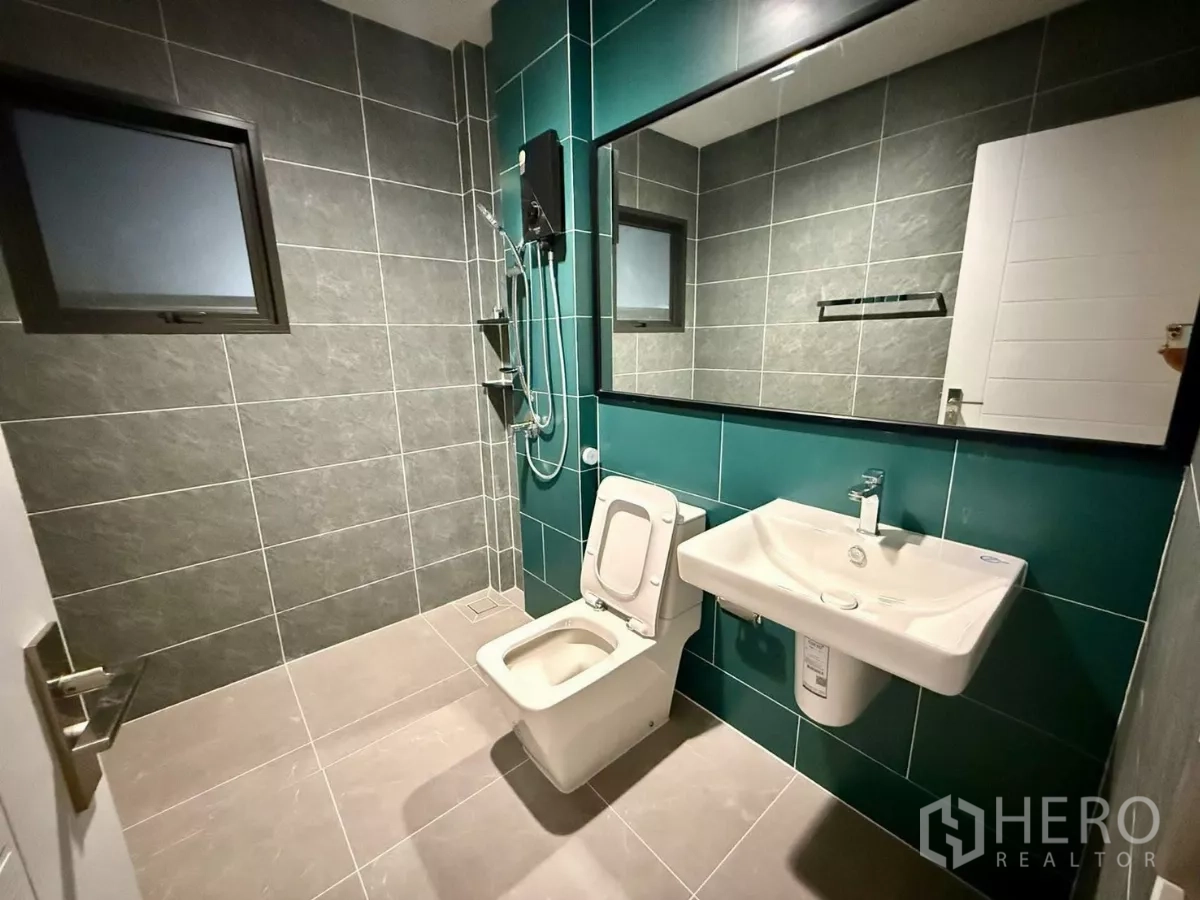 Detached House for rent in Bang Phli, Samut Prakan - Bathroom with teal accent tiles, large mirror and walk-in shower.