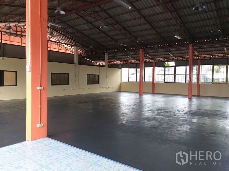 货栈 出租在Khlong Sam Wa, Bangkok - 入口望向仓库内部，高柱、办公区与侧窗清晰可见。
