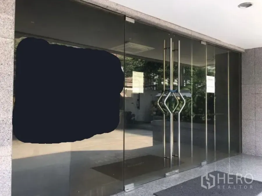 办公空间 出租在Pathum Wan, Bangkok - 商业建筑的玻璃门入口，配不锈钢双把手。