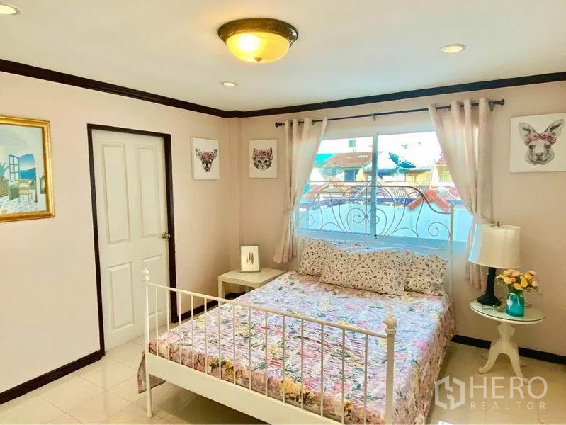 ทาวน์เฮาส์ ให้เช่าหรือขายในPrawet, Bangkok - ห้องนอนเตียงคู่ มีหน้าต่างระเบียง โต๊ะข้างเตียง และผ้าม่าน