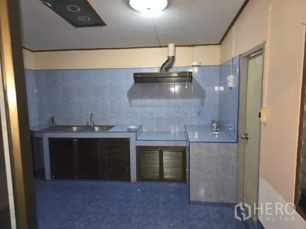 Home Office for rent in Wang Thonglang, Bangkok - Practical Thai kitchen with blue wall and floor tiles, double sink, range hood and built-in counters.