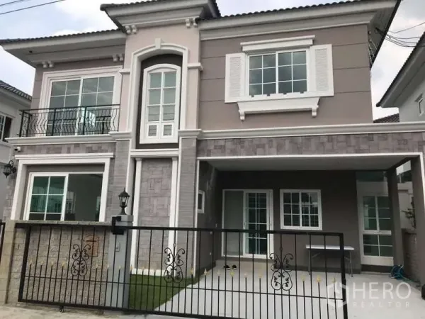 Detached House for rent in Chom Thong, Bangkok - Front exterior showing gated driveway, balcony railings and generous windows.