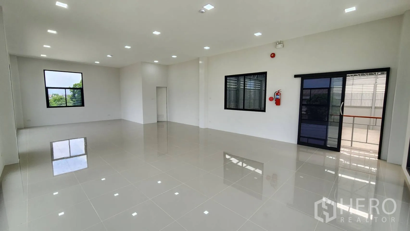 Factory for rent or sale in Bang Bo, Samut Prakan - Open‑plan office with sliding glass door to warehouse, LED lighting and fire safety fixtures.