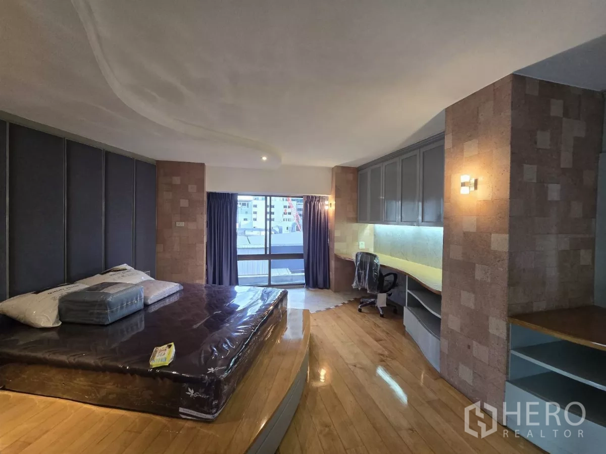 公寓 出租在Pathum Wan, Bangkok - 大卧室，抬高床台、内置书桌，连通阳台看城市景