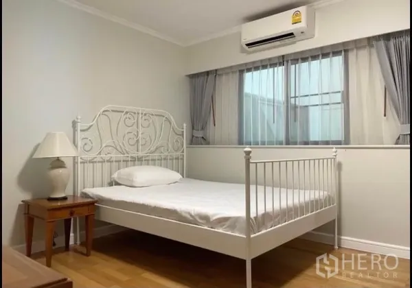 公寓 出租在Sathon, Bangkok - 温馨卧室，白色金属床架、窗帘与空调。